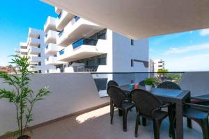 un balcon avec une table et des chaises et un bâtiment dans l'établissement Apartamento costero en una comunidad de lujo, à Arenales del Sol