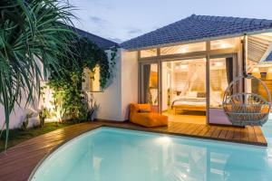 a house with a swimming pool and a bedroom at Villa Cemacase in Cemagi