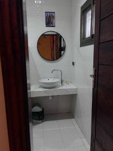 a bathroom with a sink and a mirror at Hotel KEUR HORUS in Saint-Louis +19 photos