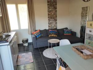 a living room with a couch and a table at Les chambres d hôtes de Jade in Pujaut