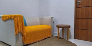 a yellow blanket on a couch next to a stool at Refúgio no Mirante in São Lourenço