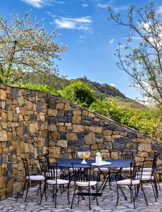 a table and chairs on a patio with a stone wall at Villa Mosor Mit Beheiztem Salzwasserpool Und Sauna in Omiš