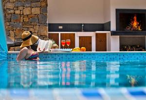 a woman in a hat sitting in a swimming pool at Villa Mosor Mit Beheiztem Salzwasserpool Und Sauna in Omiš +32 photos