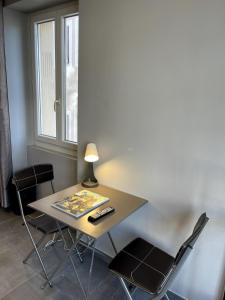 a table with two chairs and a lamp on it at Studio - Travail & Détente - Puy in Le Puy en Velay