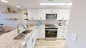 Una cocina con gabinetes blancos y un fregadero. en SeaCrest 714, en Fort Walton Beach