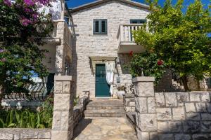 a stone house with a blue door at Apartment Pepica in Postira