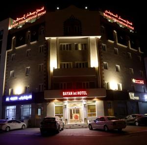 Mawāliḩ巴彦国际酒店的前面停着汽车的建筑物