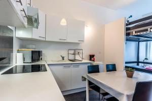 eine Küche mit weißen Schränken und einem Tisch mit Stühlen in der Unterkunft LyonPaulBert in Lyon + 11 Fotos