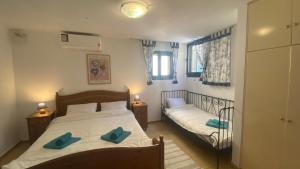 a bedroom with a bed with two blue pillows on it at Barbati Olive in Barbati
