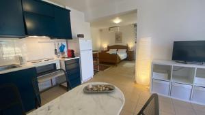 a kitchen with a table and a room with a bed at Barbati Olive in Barbati