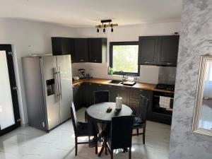 a kitchen with a table with chairs and a refrigerator at Furnicuta in Curtea de Argeş