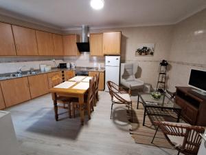a kitchen with a table and chairs and a refrigerator at Ninho das Andorinhas in Monção