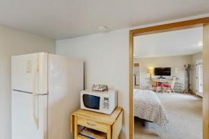 a kitchen with a refrigerator and a tv on a table at Harbor View Studio Cottage in Gold Beach