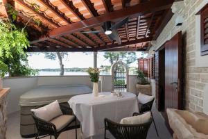 a patio with a table and chairs and a large window at Villa Nauta Peljesac, Ferienhaus Mit Whirpool in Lovište