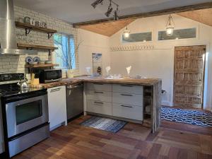 a kitchen with white appliances and a wooden floor at Bleu Azur 32 night Lakefront Retreat w Hot tub in Saint Adolphe D'Howard