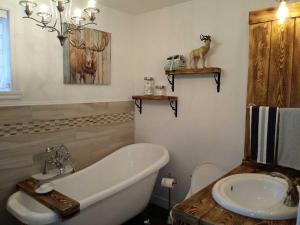 a bathroom with a bath tub and a sink at Bleu Azur 32 night Lakefront Retreat w Hot tub in Saint Adolphe D'Howard +30 photos