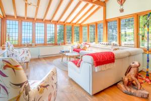 une véranda avec une grande pièce avec des fenêtres dans l'établissement Greenhill Cottage Sea Views with Thatched Charm, à Beer 47 autres photos