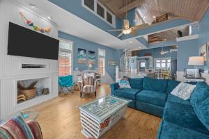 a living room with a blue couch and a tv at Dolphin Dreams home in Atlantic Beach