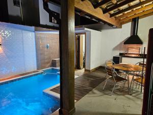 einen Pool mit einem Tisch und einem Esszimmer in der Unterkunft Casa em Boiçucanga com 2 suítes, piscina e sauna integrada in São Sebastião