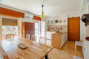 Una cocina y un comedor con una mesa de madera. en The Best View Sicily&Jacuzzi, en Carini