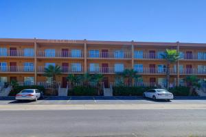 two cars parked in a parking lot in front of a hotel at Fiesta Sol Condominiums 212 in South Padre Island