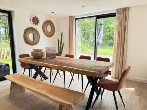 a dining room with a wooden table and chairs at LouLou Beachhouse in Julianadorp +22 photos