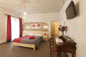 een slaapkamer met een bed, een bureau en een piano bij Agriturismo La Collina in Pitigliano +20 foto's