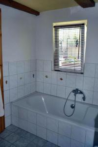 a bath tub in a bathroom with a window at Freistehendes Ferienhaus In Ruhiger Lage in Rubitz