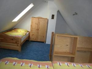 a attic room with two beds and wooden cabinets at Freistehendes Ferienhaus In Ruhiger Lage in Rubitz +1 photo