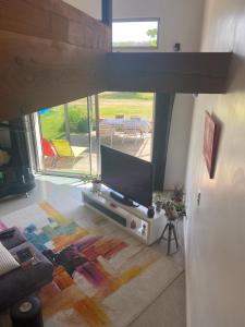 a living room with a flat screen tv on a table at chambre deux personnes, lit pour Bébé in Verlhac-Tescou