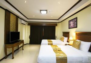 a hotel room with two beds and a television at i Boutique Hotel in Pluak Daeng