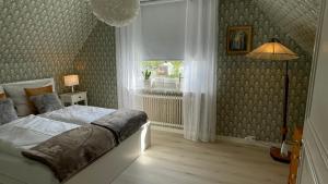 a bedroom with a bed and a window and a lamp at Villa ASTRID PremiumFerienhaus inkl Bettwäsche Handtücher in Storebro +40 photos