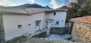 una casa blanca con una montaña al fondo en Calme, détente, balades, nature en Cévennes, en Cros