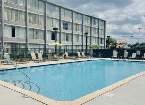 a large swimming pool in front of a hotel at Wyndham Garden Greensboro in Greensboro