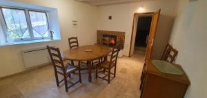 Un comedor con mesa y sillas y chimenea. en Calme, détente, balades, nature en Cévennes, en Cros