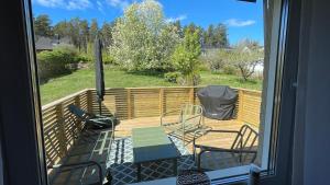 a deck with two chairs and a table and chairs at Villa ASTRID PremiumFerienhaus inkl Bettwäsche Handtücher in Storebro