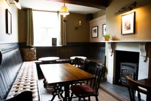 a restaurant with a table and chairs and a fireplace at Red Bull in Stockport