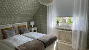 a bedroom with a bed and a window at Villa ASTRID PremiumFerienhaus inkl Bettwäsche Handtücher in Storebro