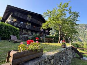 a house with flowers on a stone wall at Chalet Il Pruno del Rosa in Macugnaga