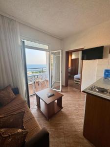ein Wohnzimmer mit Sofa und eine Küche mit Meerblick in der Unterkunft Adriatic Apartments in Ulcinj
