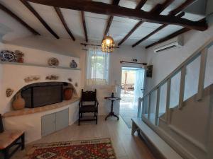 a living room with a television and a table at Avra traditional Blue house, Elma's Houses in Alonnisos Old Town