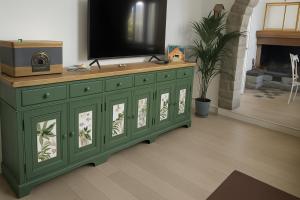 a green dresser with a television on top of it at B&B Il Fiore nel Bosco in Orte