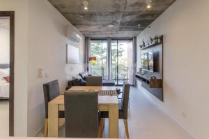 Un comedor y una sala de estar con mesa y sillas. en Apartment Located Steps From Shopping Del Sol, en Asunción