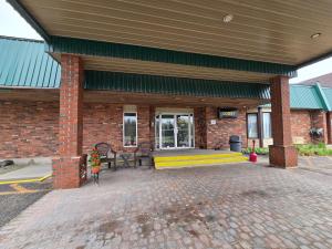 a brick building with a bench in front of it at Airport Motor Inn in Marathon