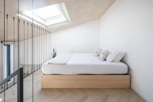 ein Schlafzimmer mit einem Bett und einem Dachfenster in der Unterkunft T0 do Carril, Aveiro in Aveiro