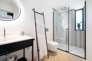 ein Badezimmer mit Dusche, Toilette und Waschbecken in der Unterkunft T0 do Carril, Aveiro in Aveiro + 10 Fotos