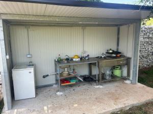 a garage with a table and a kitchen in it at Camping Volme Tent in Banjole