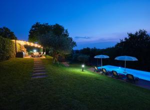 a backyard with a swimming pool at night at Villa Beatrice in Verona