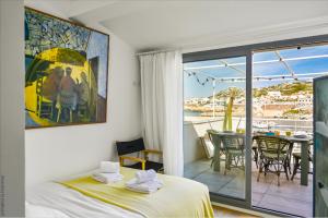 a bedroom with a bed and a balcony with a table at Cabin, waterfront terrace in Marseille