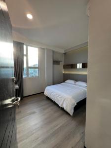 a bedroom with a bed and a large window at LeLian Hotel SIBUJAYA in Sibu